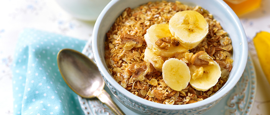 A bowl of oatmeal topped by slices of banana