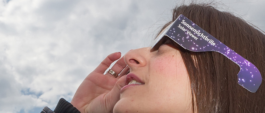 Women wearing solar eclipse glasses
