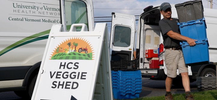 VYCC staff unloading Health Care Share food bins from vans