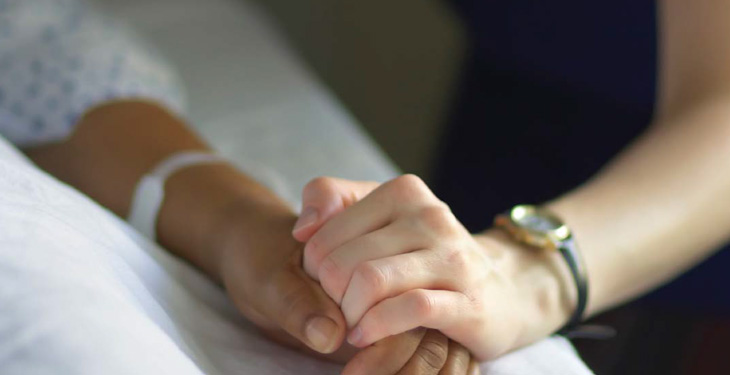 Nursing holding patient's hand.