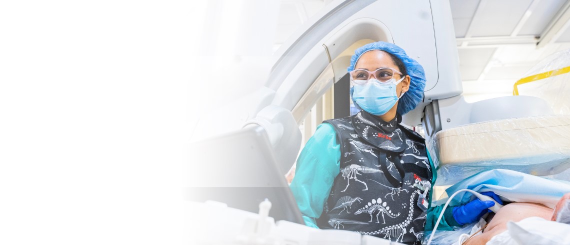 Female technician performing TAVR procedure.