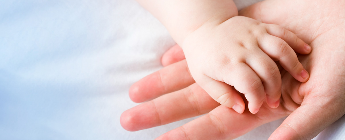 Baby's hand on top of mother's hand