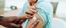 Provider putting a bandaid on patient after receiving flu shot